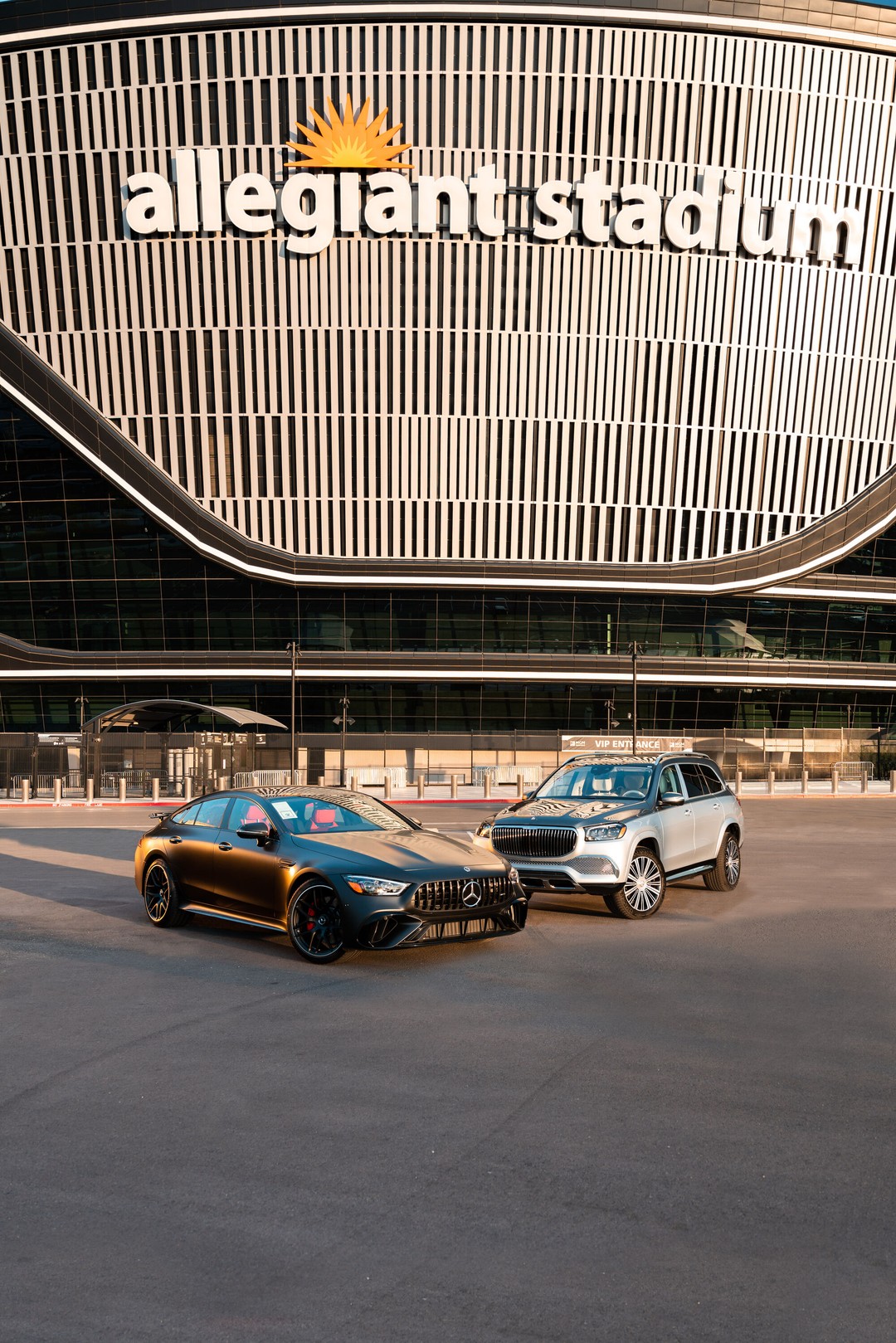 Mercedes-AMG GT four-door coupe and Mercedes-Maybach GLS parked in front of Allegiant Stadium at golden hour, Las Vegas